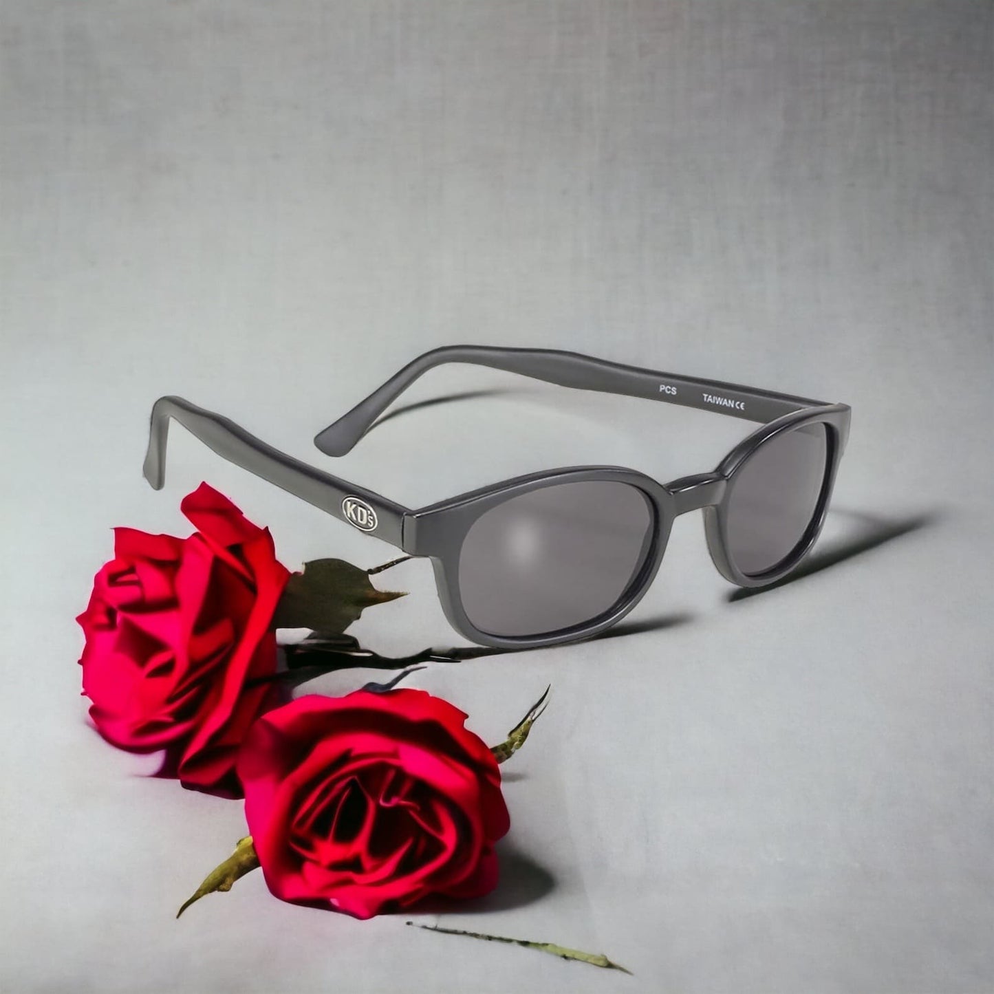 KD's 20010 sunglasses worn by Jax Teller and the members of SAMCRO in Sons of Anarchy, which fit under a helmet. With a solid matte black frame and polycarbonate sunglasses set behind roses.