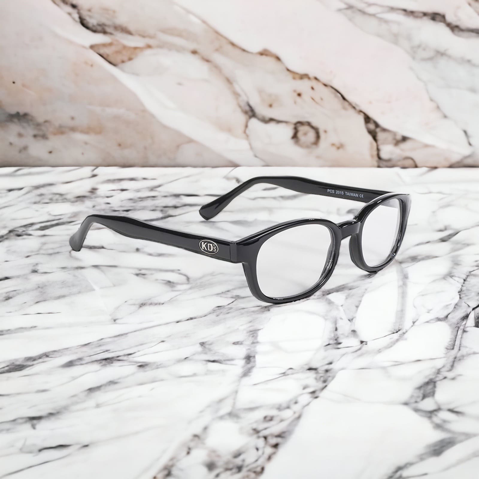 The sunglasses KD's 2015 that fit under a ski or motorcycle helmet with transparent lenses placed on a white marble countertop.