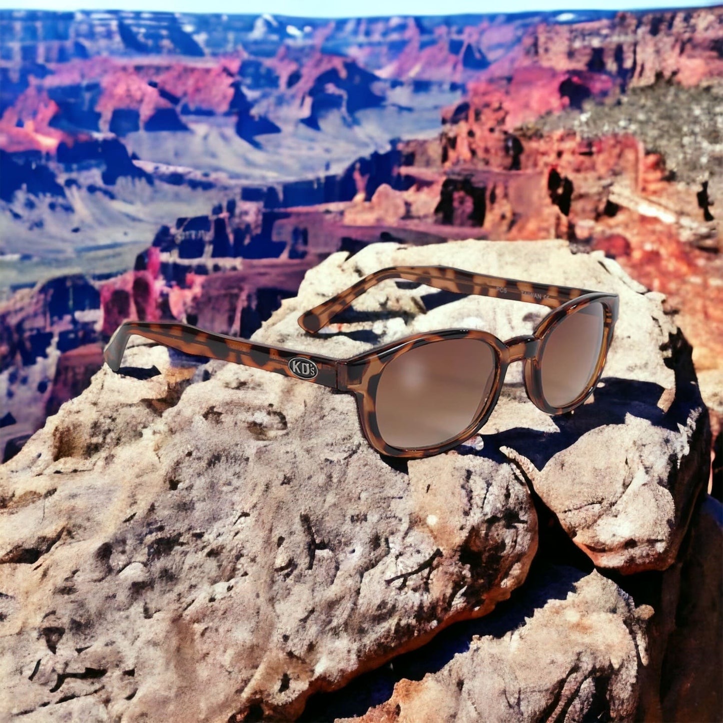 KD's 200 sunglasses with a turtle shell decor frame and amber lenses perched on one of the mountains of the Grand Canyon