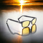 X-KD's 10112 large sunglasses with a stylish black frame and yellow polycarbonate lenses in front of a sunset.