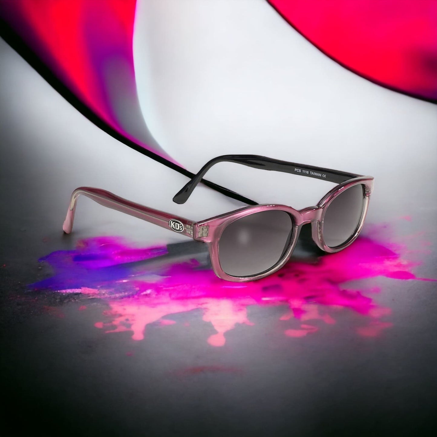 The X-KD's 1116 sunglasses with grey lenses and an elegant pink frame in a decor with paint