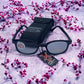 The X-KD's 1011 Day2Nite sunglasses with photochromic lenses laid on a ground with cherry blossoms.