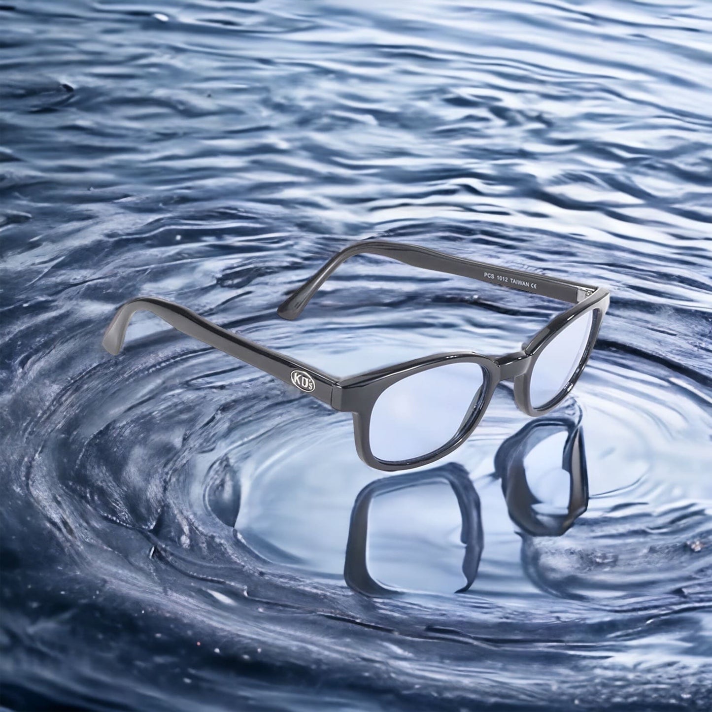 The X-KD's 1012 sunglasses with blue lenses and a distinct black frame placed on the water.